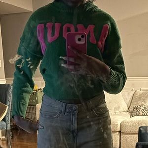Green turtleneck sweater that say amour.